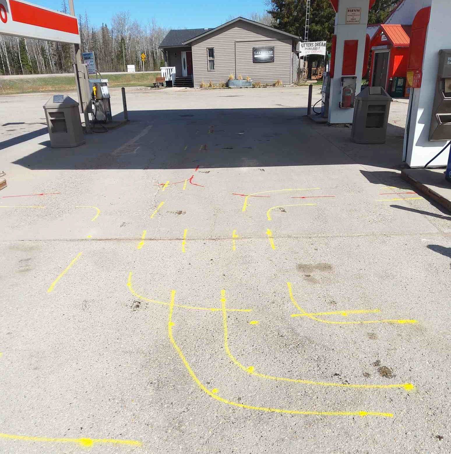 Colour-coded utility paint marks on a concrete pad